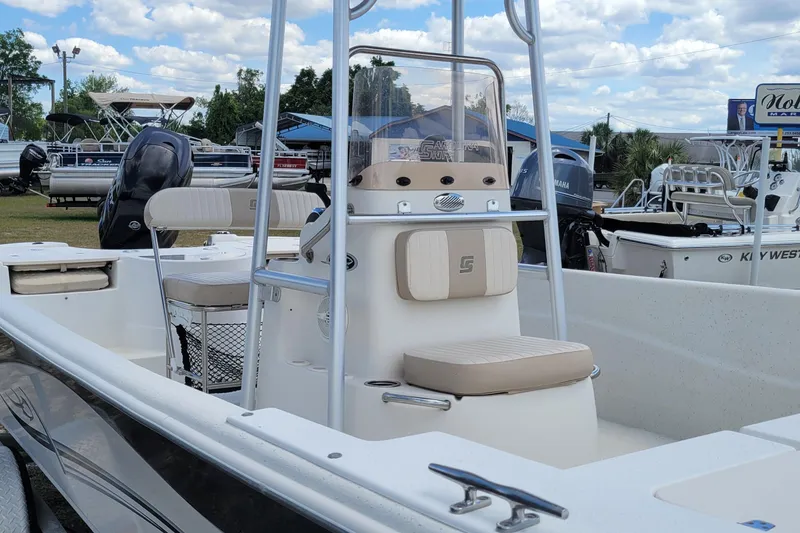 Slide: The Image of 2014 Carolina Skiff 218 DLV boat with seating and console, displayed outdoors. - 5