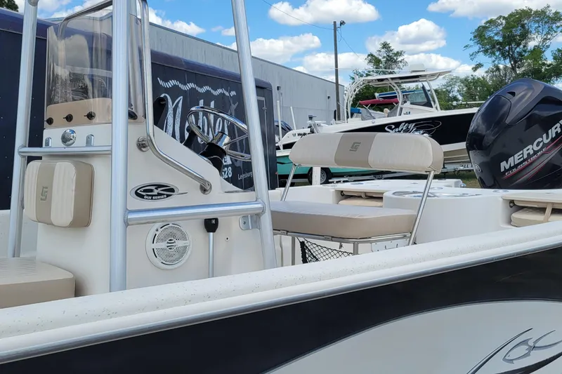 Slide: The Image of 2014 Carolina Skiff 218 DLV boat with Mercury engine, featuring a sleek console and seating. - 7