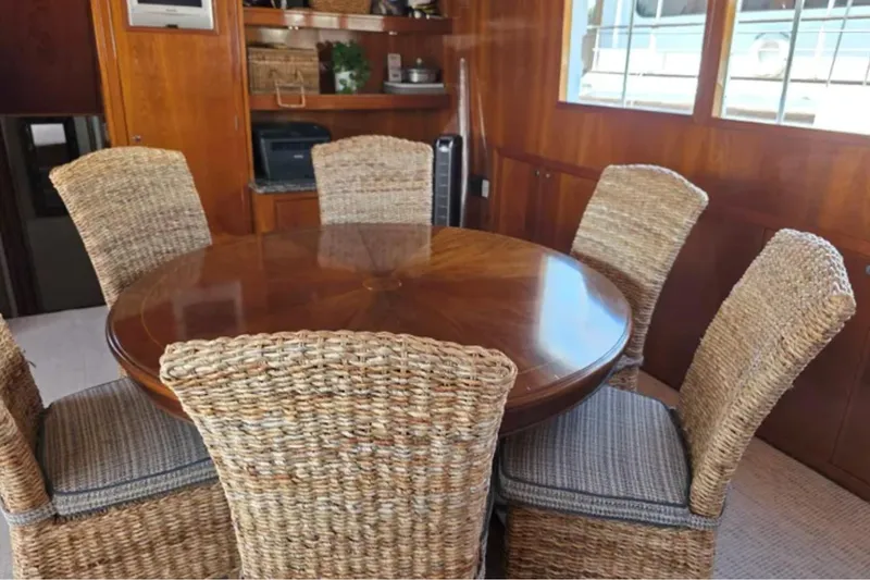 Slide: The Image of Dining area on 1974 Chris-Craft 68 Roamer Flush Deck with wicker chairs and wooden table. - 4
