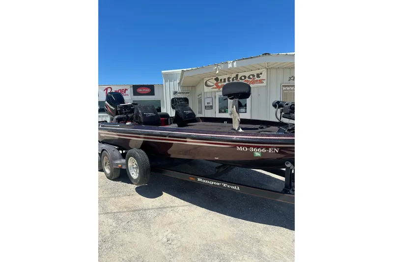 Slide: The Image of 1993 SeaRanger 492V boat on trailer, parked outside a marine store under clear blue sky. - 4