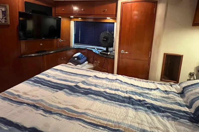 Slide: The Image of Interior cabin of 2000 Carver 506 Motor Yacht with bed, TV, and wooden cabinetry. - 11