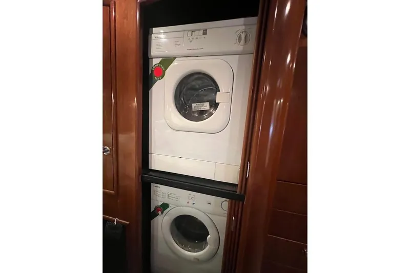 Slide: The Image of Stacked washer and dryer inside 2000 Carver 506 Motor Yacht's wooden interior. - 13