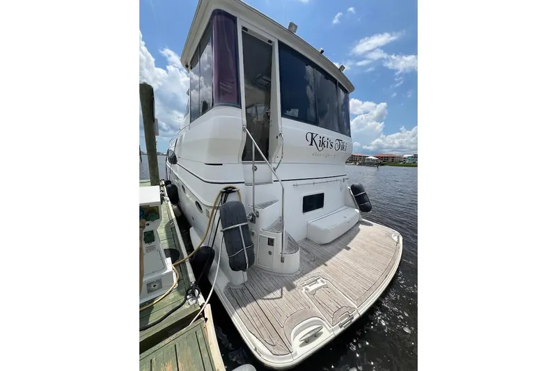Slide: The Image of Carver 506 Motor Yacht 2000 docked, rear view with clear sky and water backdrop. - 41