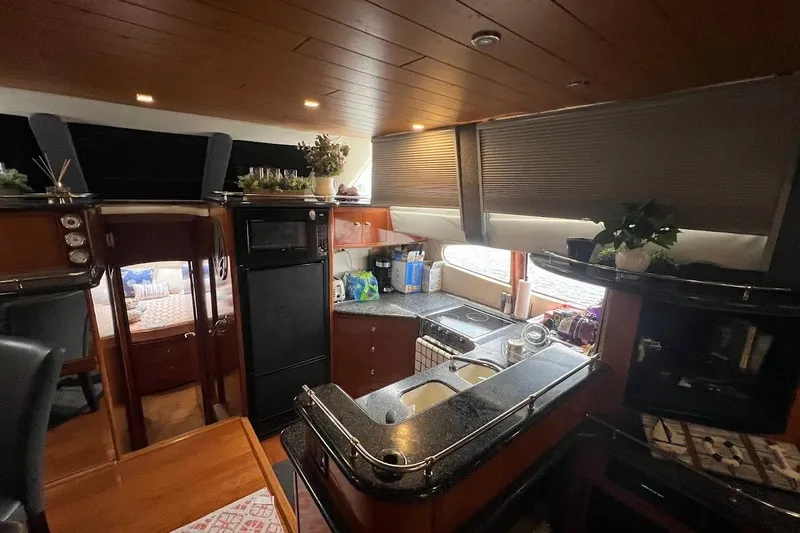 Slide: The Image of Interior of 2000 Carver 506 Motor Yacht with modern kitchen and wooden finishes. - 6