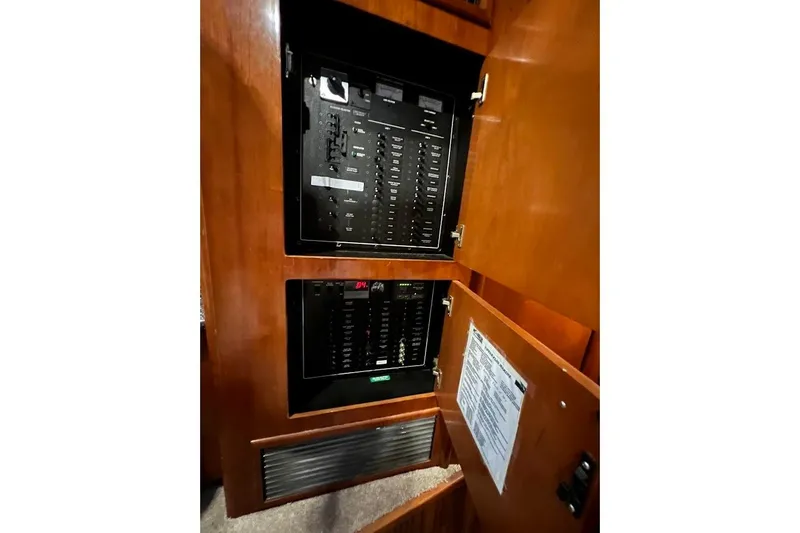 Slide: The Image of Electrical panel inside 2000 Carver 506 Motor Yacht, featuring wooden cabinetry. - 9