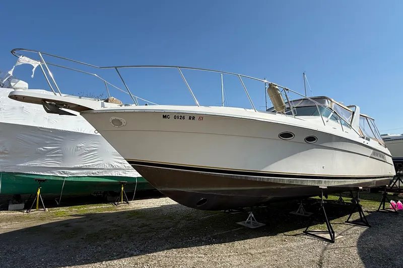 The Image of 1992 Wellcraft 3400 Gran Sport boat on stands outdoors. - 0