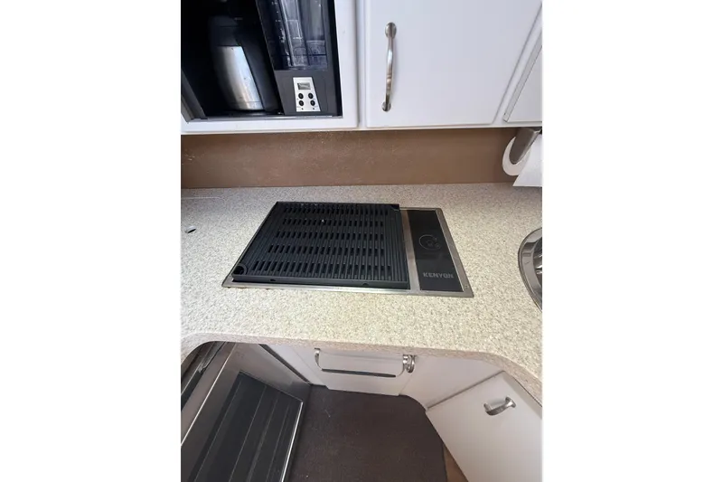 Slide: The Image of 1992 Wellcraft 3400 Gran Sport kitchen with Kenyon cooktop on beige countertop. - 18