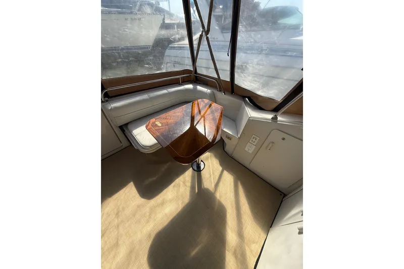 Slide: The Image of Interior of 1992 Wellcraft 3400 Gran Sport with wooden table and cushioned seating. - 7