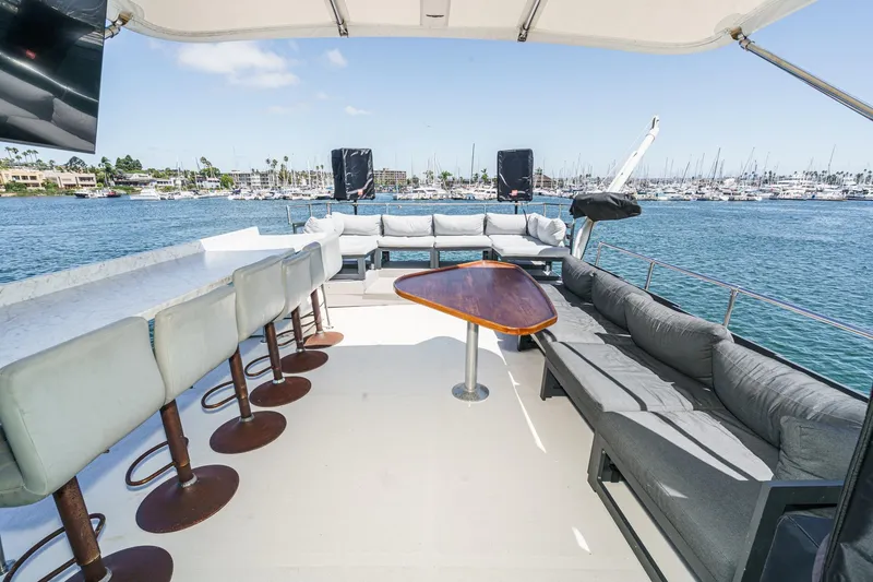 Slide: The Image of 1979 Hatteras 58 Motor Yacht deck with seating, bar stools, and ocean view. - 17