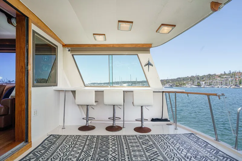 Slide: The Image of 1979 Hatteras 58 Motor Yacht interior with bar stools, overlooking marina. - 32