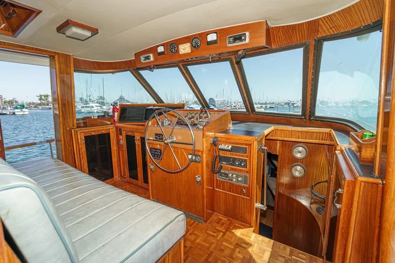 Slide: The Image of 1979 Hatteras 58 Motor Yacht helm with wood paneling and marina view. - 42