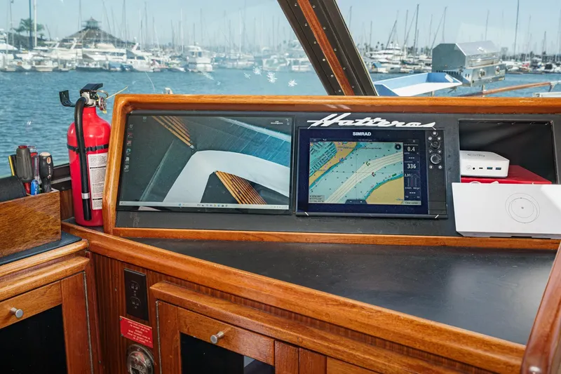 Slide: The Image of 1979 Hatteras 58 Motor Yacht helm with navigation screens and marina view. - 45