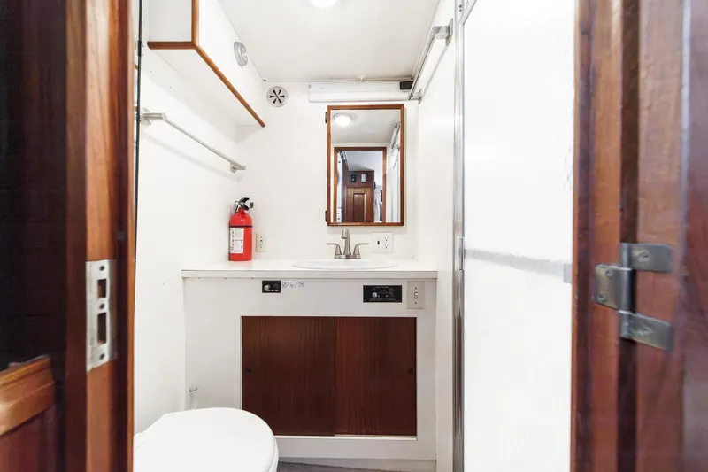 Slide: The Image of 1979 Hatteras 58 Motor Yacht bathroom with sink, mirror, and fire extinguisher. - 52