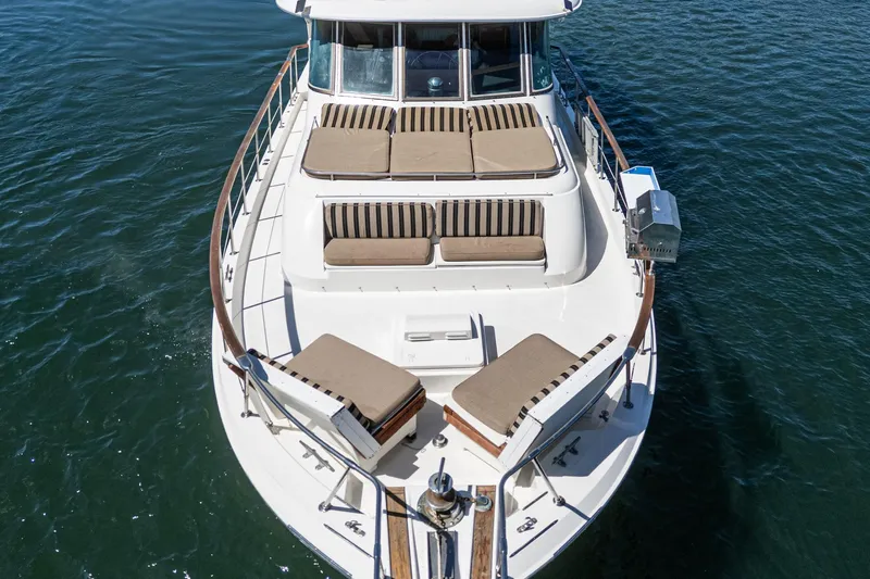 Slide: The Image of 1979 Hatteras 58 Motor Yacht with sun loungers on deck, cruising on water. - 8