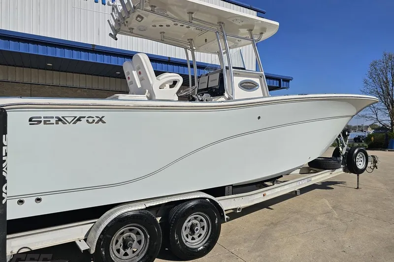 Slide: The Image of 2013 Sea Fox 286 Commander boat on trailer, parked outdoors under clear blue sky. - 10