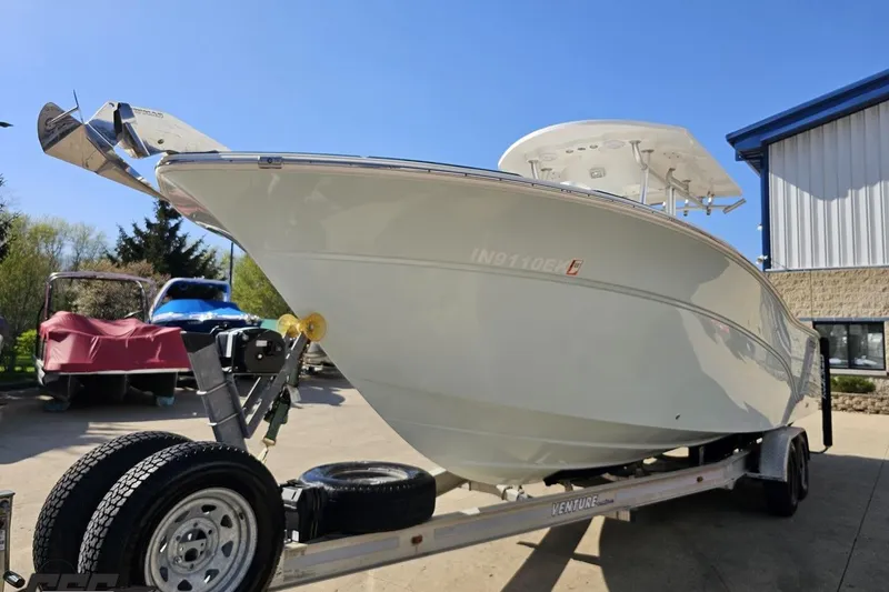 Slide: The Image of 2013 Sea Fox 286 Commander boat on trailer, parked outdoors under clear blue sky. - 18