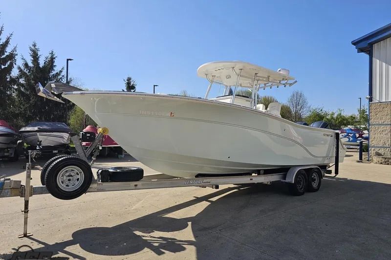 Slide: The Image of 2013 Sea Fox 286 Commander boat on trailer, parked outdoors under clear blue sky. - 20