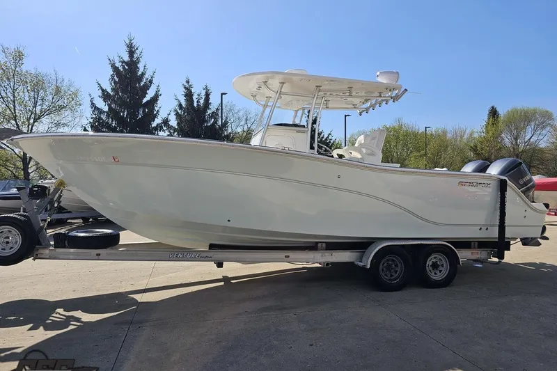 Slide: The Image of 2013 Sea Fox 286 Commander boat on trailer, parked outdoors with trees in background. - 21