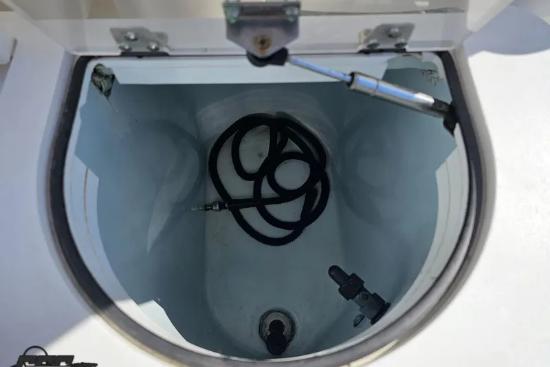 Slide: The Image of Open storage compartment on a 2013 Sea Fox 286 Commander boat, featuring coiled hose inside. - 60