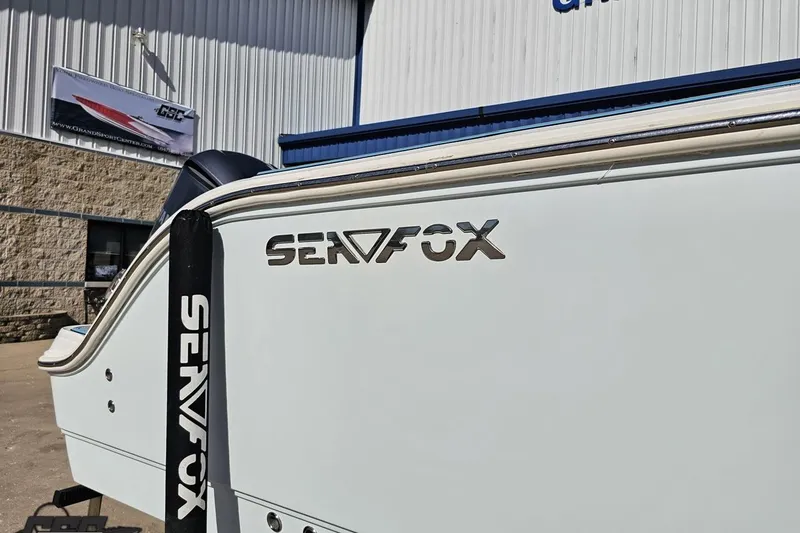 Slide: The Image of 2013 Sea Fox 286 Commander boat exterior with logo, displayed at a dealership. - 7