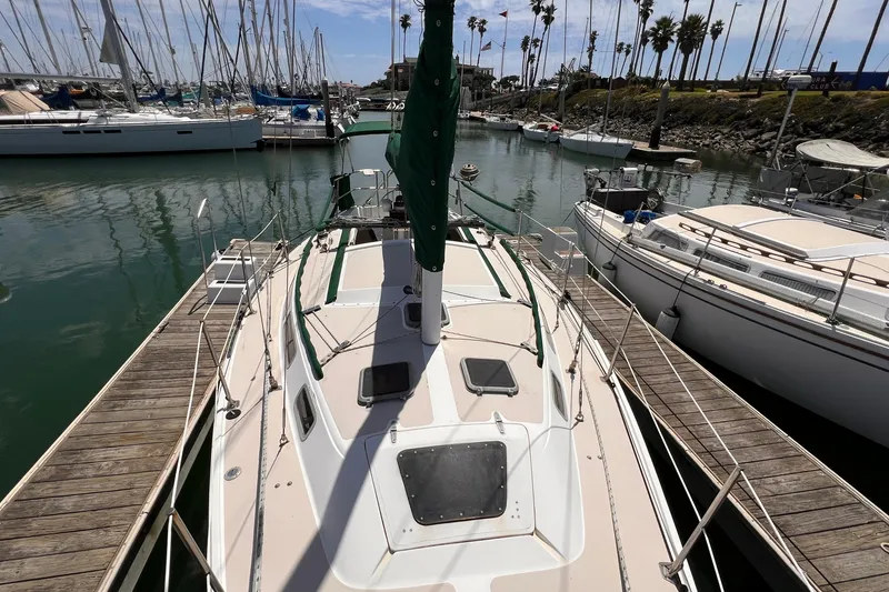Slide: The Image of 1984 Catalina 30 sailboat docked in a marina with palm trees in the background. - 11