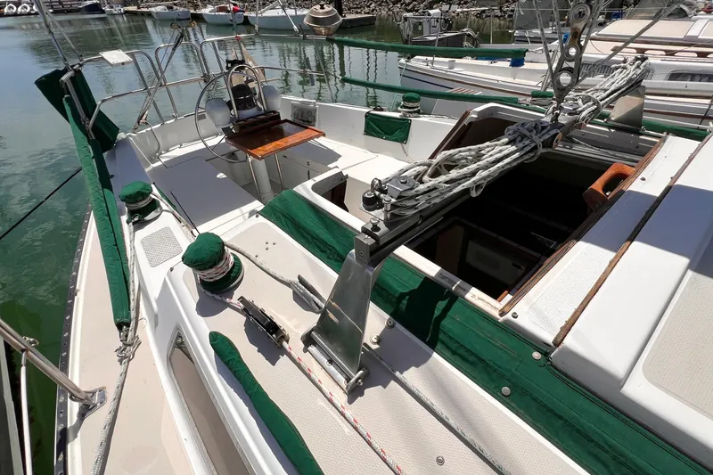 Slide: The Image of 1984 Catalina 30 sailboat cockpit with green accents, docked in a marina. - 15