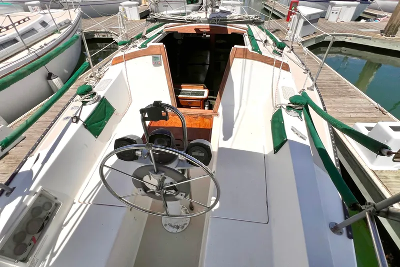 Slide: The Image of Cockpit view of a 1984 Catalina 30 sailboat docked at a marina. - 16