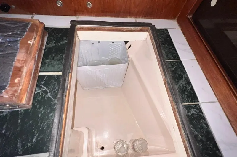 Slide: The Image of Built-in storage compartment on a 1984 Catalina 30 sailboat, featuring a plastic organizer. - 23