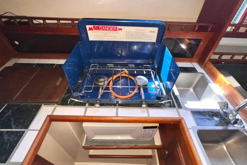 Slide: The Image of 1984 Catalina 30 yacht kitchen with blue portable stove and dual sinks. - 26