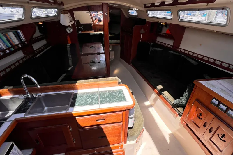Slide: The Image of Interior of a 1984 Catalina 30 sailboat with wood cabinetry and seating area. - 27