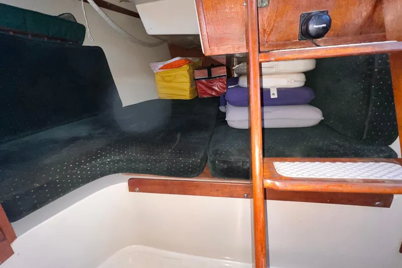 Slide: The Image of Interior cabin of a 1984 Catalina 30 sailboat with cushions and storage. - 30
