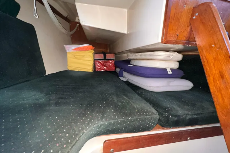 Slide: The Image of Interior cabin of a 1984 Catalina 30 sailboat with cushions and storage bags. - 31