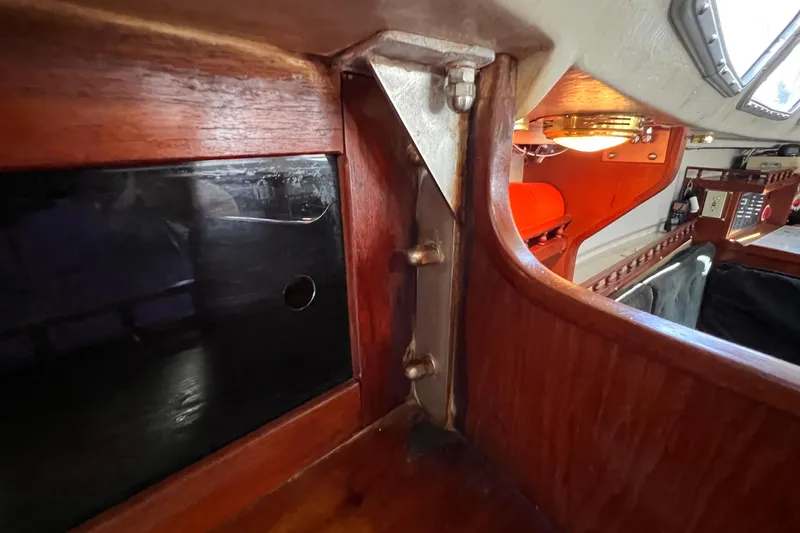 Slide: The Image of Interior view of a 1984 Catalina 30 sailboat, showcasing wooden cabinetry and metal fixtures. - 35