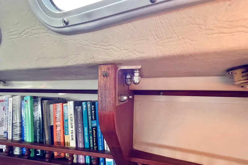 Slide: The Image of Interior of 1984 Catalina 30 sailboat with bookshelf and wooden bracket detail. - 36