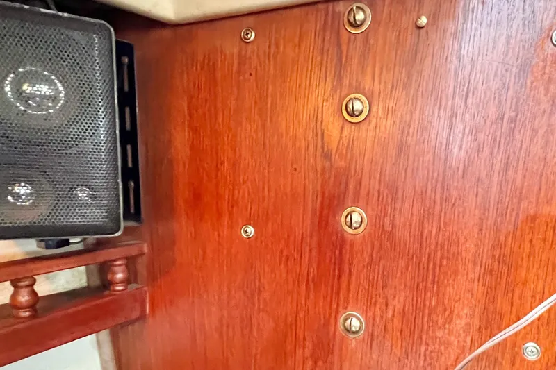 Slide: The Image of Wooden interior of a 1984 Catalina 30 sailboat with brass fittings and a speaker. - 38