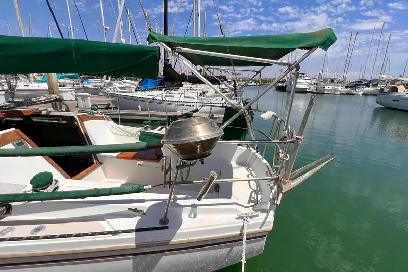 Slide: The Image of 1984 Catalina 30 sailboat docked in marina with green canopy and stainless steel grill. - 4