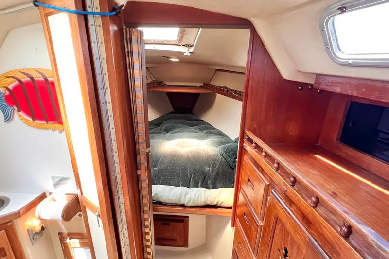 Slide: The Image of Interior of a 1984 Catalina 30 sailboat with cozy wooden cabin and bed. - 42