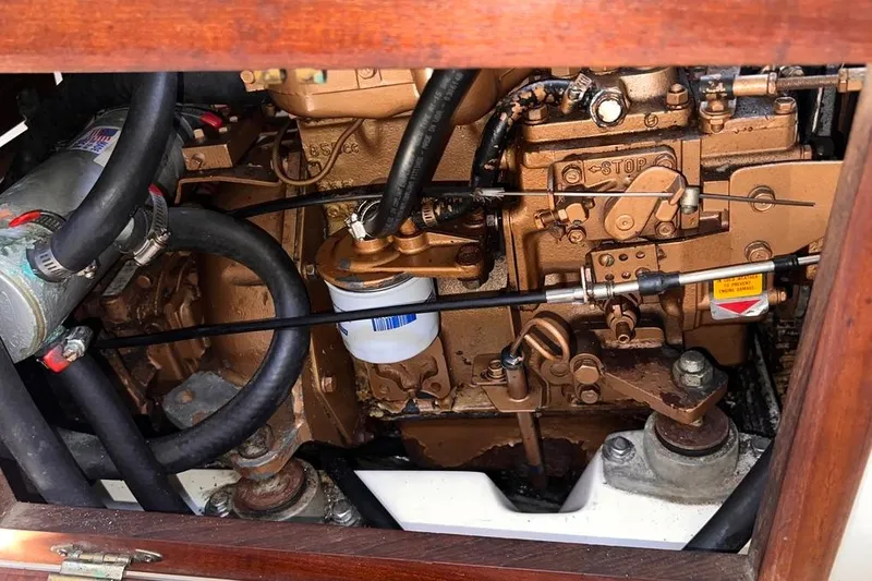 Slide: The Image of Engine compartment of a 1984 Catalina 30 sailboat, showcasing mechanical components and hoses. - 50