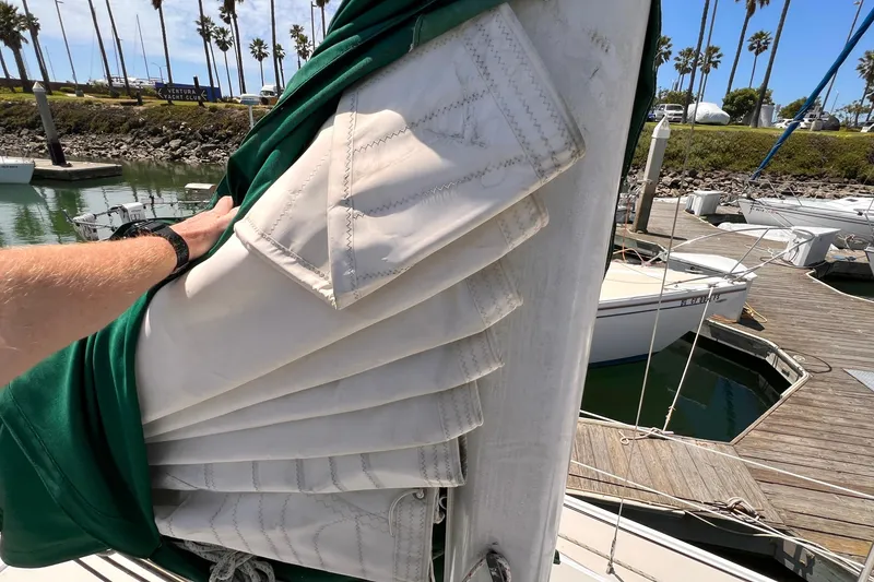 Slide: The Image of Sailboat mast with folded sail, Catalina 30, 1984, docked at marina with palm trees. - 8