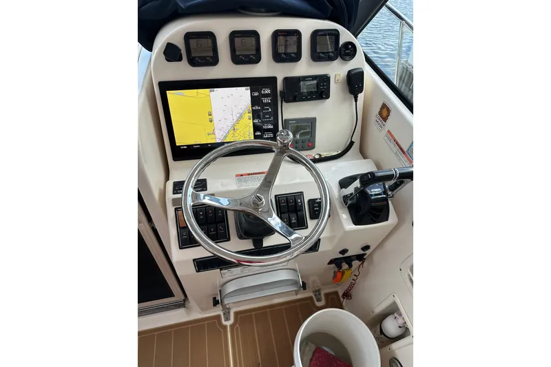 Slide: The Image of 2008 Pursuit OS 335 Offshore helm with navigation display and controls. - 18