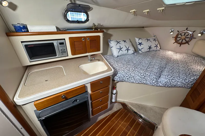 Slide: The Image of Interior of 2008 Pursuit OS 335 Offshore with kitchenette and cozy sleeping area. - 23