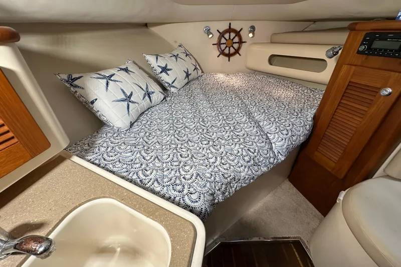 Slide: The Image of Cozy cabin interior of 2008 Pursuit OS 335 Offshore with nautical bedding and wooden accents. - 24