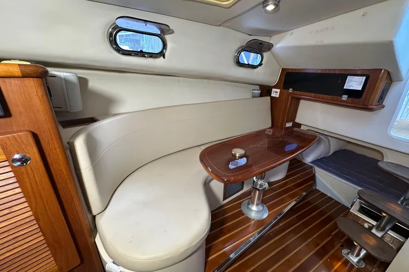 Slide: The Image of 2008 Pursuit OS 335 Offshore cabin interior with wood accents and seating area. - 25