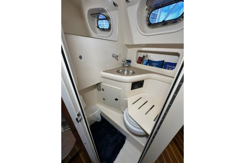 Slide: The Image of Compact bathroom in 2008 Pursuit OS 335 Offshore boat with sink and storage. - 27