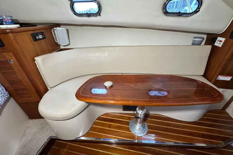 Slide: The Image of 2008 Pursuit OS 335 Offshore cabin interior with wooden table and cushioned seating. - 29