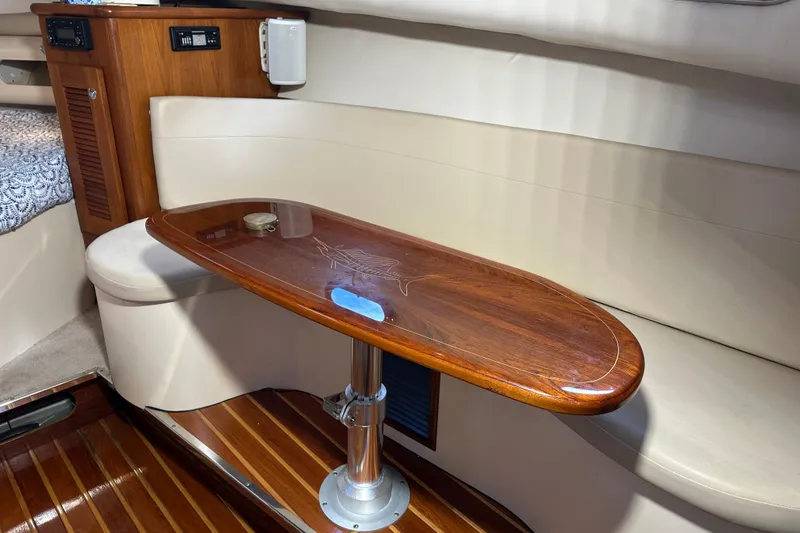Slide: The Image of Interior of 2008 Pursuit OS 335 Offshore boat with wooden table and seating area. - 32
