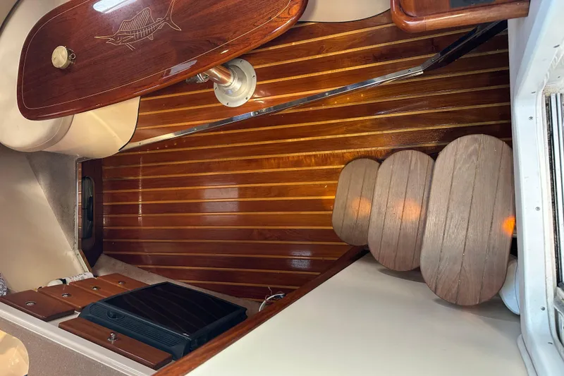 Slide: The Image of Interior of a 2008 Pursuit OS 335 Offshore boat with polished wooden flooring. - 33