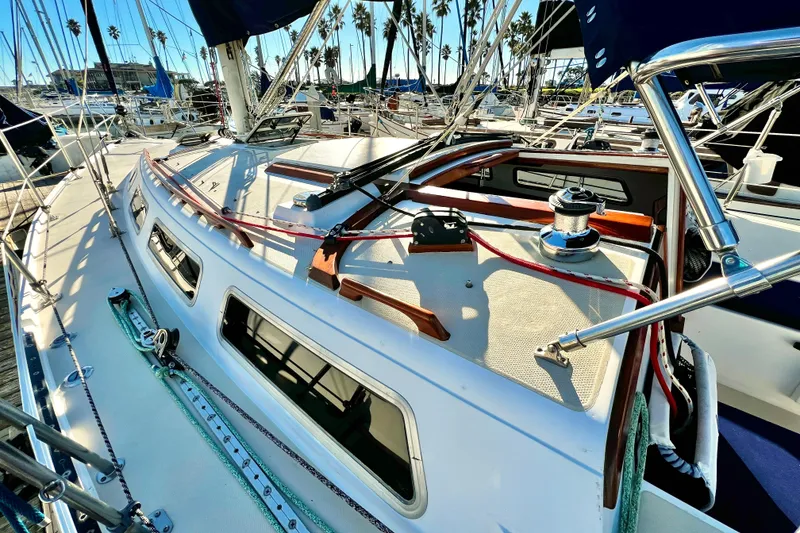 Slide: The Image of 1985 Catalina 36 sailboat deck with winch, ropes, and marina view. - 11