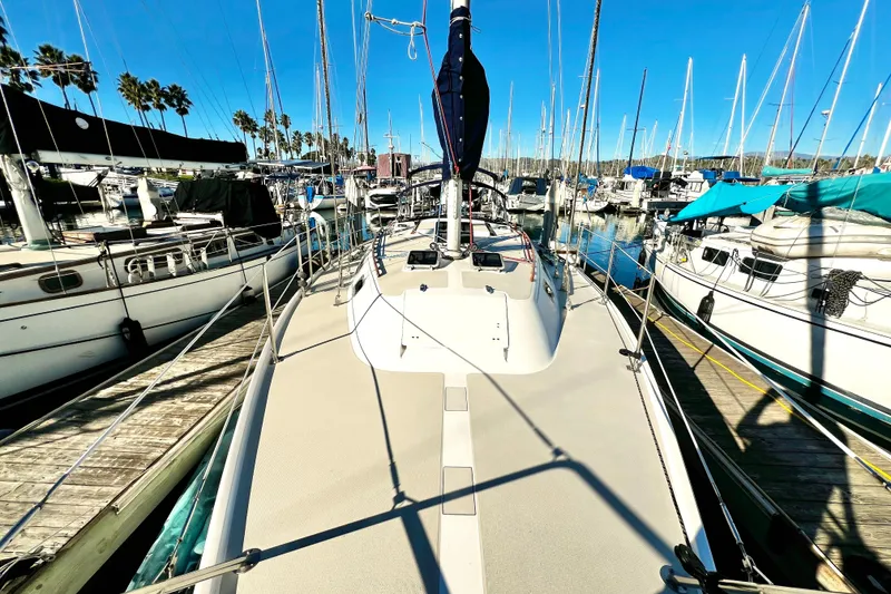 Slide: The Image of 1985 Catalina 36 sailboat docked at a marina, surrounded by other boats. - 13