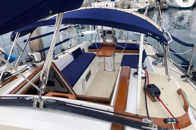 Slide: The Image of 1985 Catalina 36 sailboat cockpit with blue canopy and seating, docked at marina. - 15
